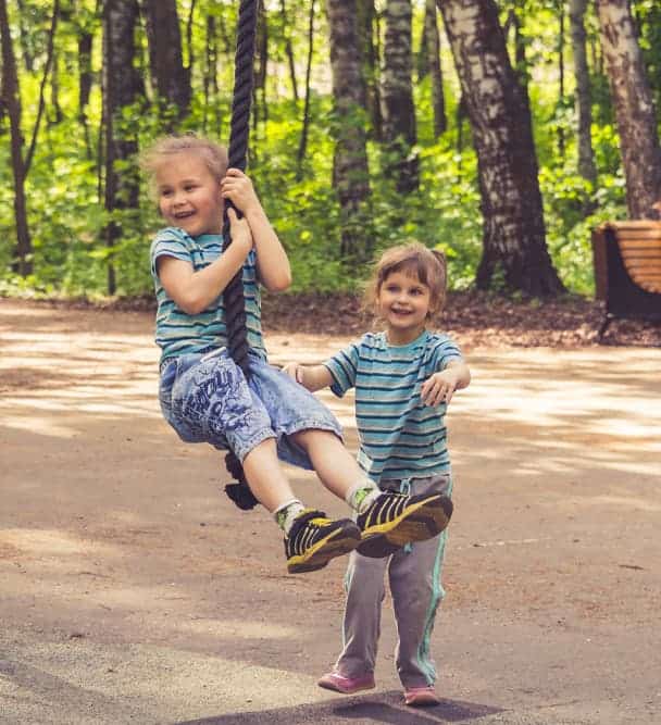 Tips for your family camping trip. Children swinging on a rope.